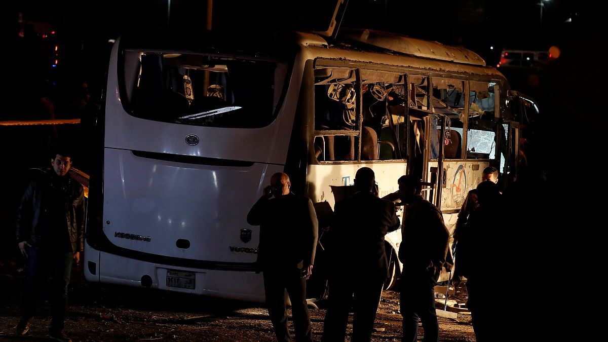 Riot police secure a scene of a bus blast in Giza