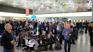 Passengers inside Hanover airport wait as flights are suspended