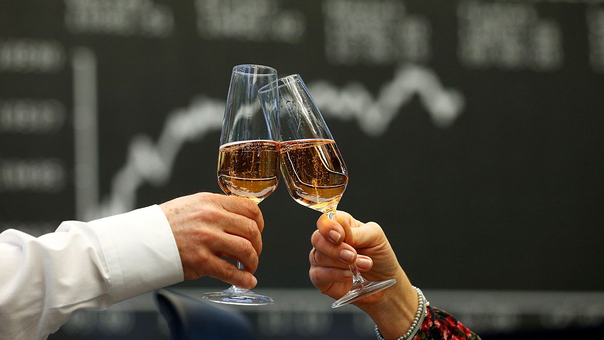 Traders raise their glasses at the stock exchange in Frankfurt