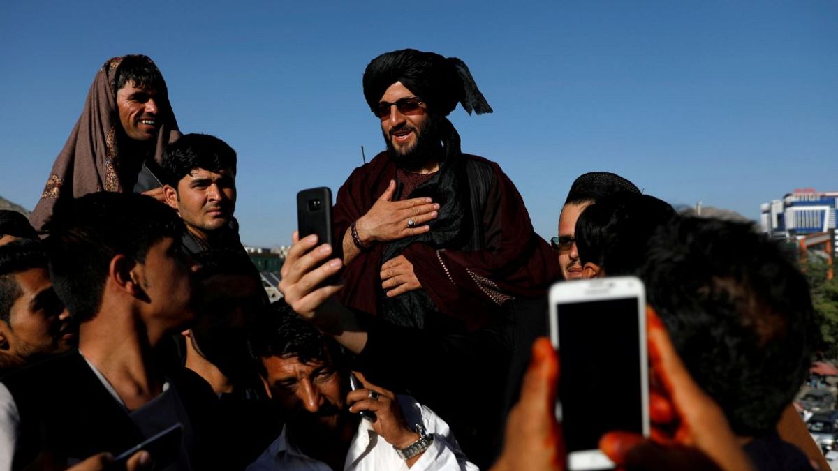 عکس از رویترز      سلفی گرفتن مردم با یکی از نیروهای طالبان در کابل 