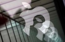 Apple-Logo-Reflektionen und Silhouette eines Menschen