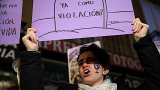 A woman protests in Madrid with a "Does it count as rape?" sign on Dec 5.