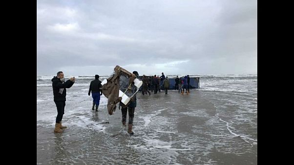 Treasure hunters pick up goods from washed up cargo shipments Treasure hunters pick up goods from washed up cargo shipments