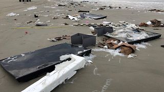 Flat-screen TVs and debris lie washed up on beach in Terschelling