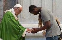 Pope Francis is greeted by a migrant as he celebrates a mass for migrants