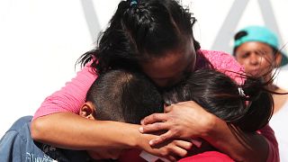 Una mujer abraza a sus hijos en el centro de acogida de Tijuana