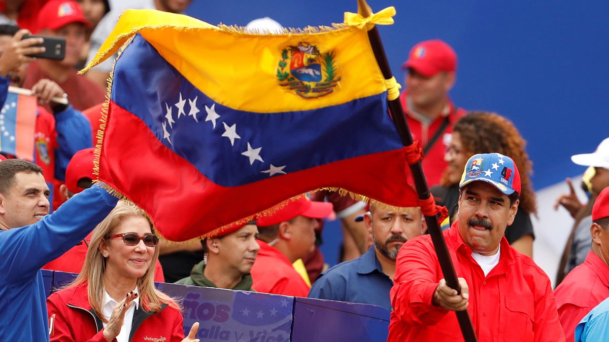 نيكولاس مادورو ملوحاً بعلم فنزويلا خلال مشاركته بذكرى الثورة البوليفارية