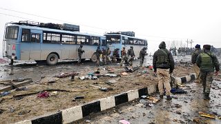 جنود هنود يفحصون حطام حافلة بعد انفجار وقع في الشطر الهندي من كشمير