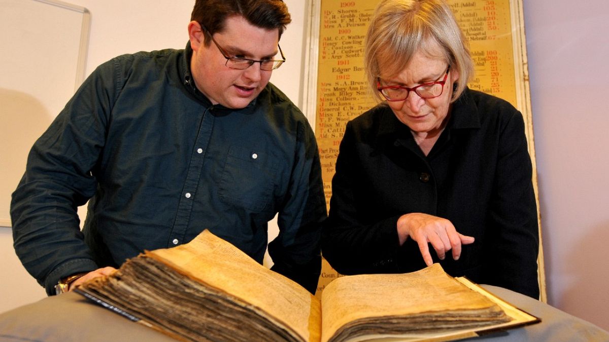 Archivist Gary Brannan and Professor Sarah Rees Jones look at the register