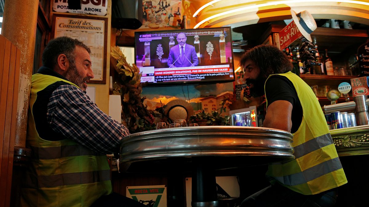 Christophe Chalencon (left) watching a televised speech by France's PM