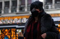 A woman covers her face as air pollution reaches dangerous levels in Skopje