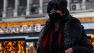 A woman covers her face as air pollution reaches dangerous levels in Skopje