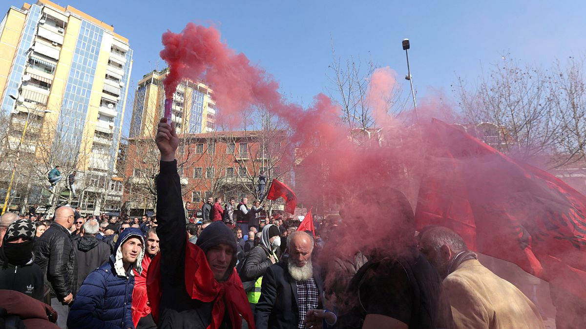 A protester holds a flare during an anti-government rally in Albania