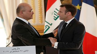 الرئيس الفرنسي إيمانويل ماكرون يصافح نظيره العراقي برهم صالح