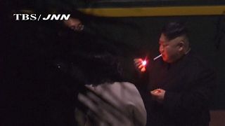 Kim Jong Un smoking at a Chinese Station