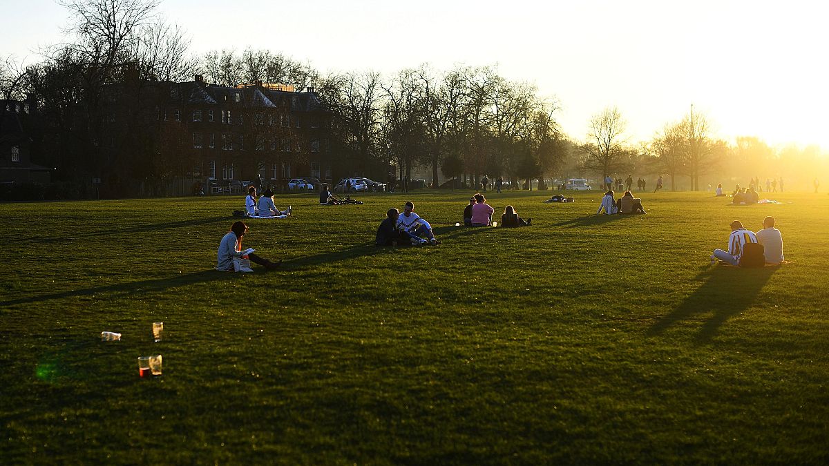 People make the most of the sun and warm weather as they sit in London