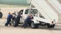 Bodyguards push the boarding steps out of the way for Air Force One