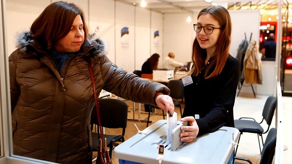 A woman casts her vote during advanced voting in Tallin A woman casts her vote during advanced voting in Tallin