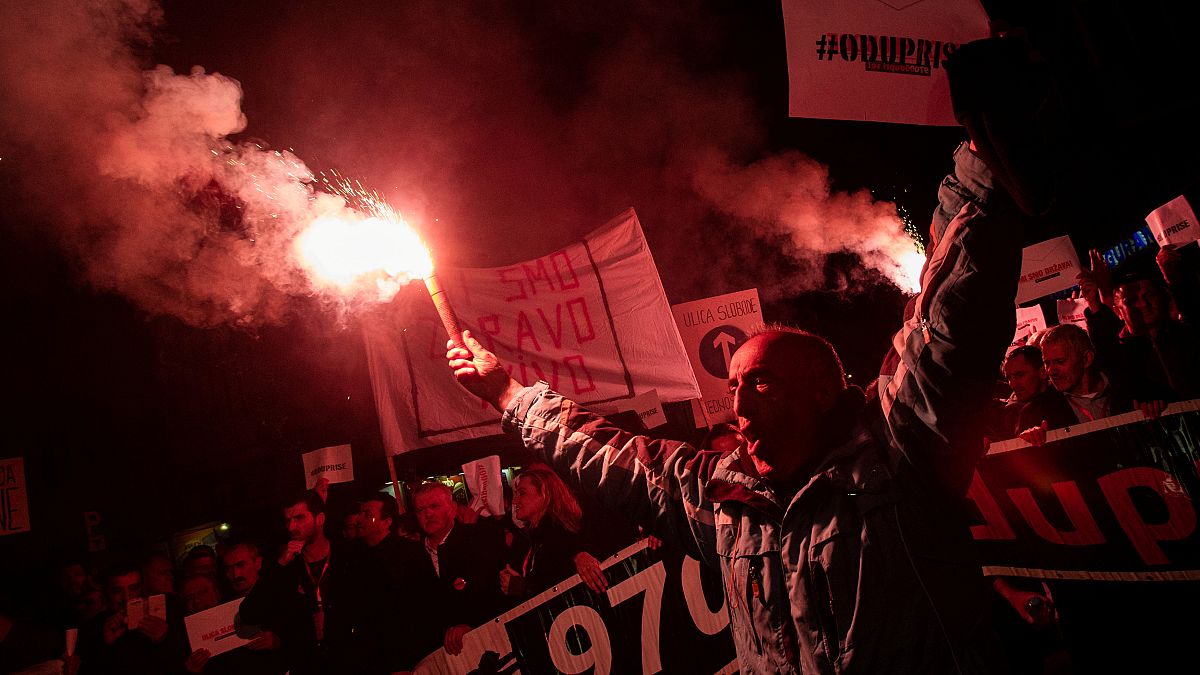 A demonstrator holds a flare during civic protest in Podgorica, Montenegro