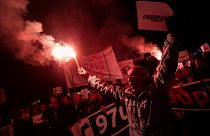 A demonstrator holds a flare during civic protest in Podgorica, Montenegro