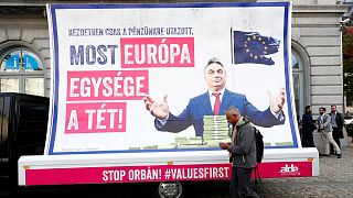A pedestrian walks past an anti-Hungary's PM Orban billboard in Brussels