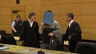 The defendant covered up his face in court with a folder
