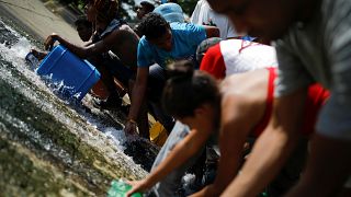 Venezolanos recogen agua con bidones en una represa