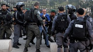 أفراد من الشرطة الإسرائيلية يعتقلون محتجا فلسطينيا خارج المسجد الأقصى