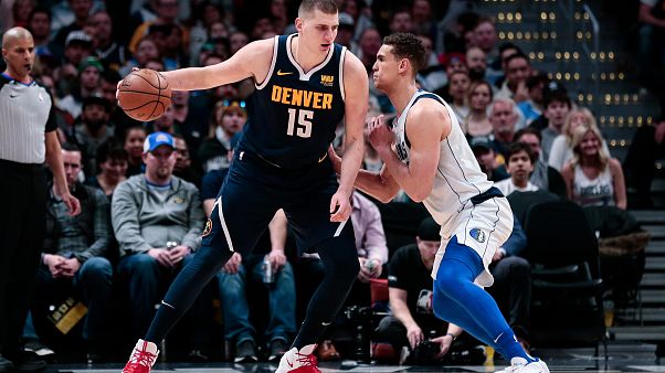 Dwight Powell prova a fermare Nikola Jokic. Dwight Powell prova a fermare Nikola Jokic.