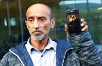 عمر نبي أمام محكمة كرايست تشيرش يحمل صورة والده الذي قضى في حادثة نيوزيلندا
