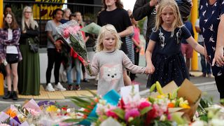 أطفال يضعون الورود ترحما على ضحايا مجزرة المسجدين في نيوزيلندا
