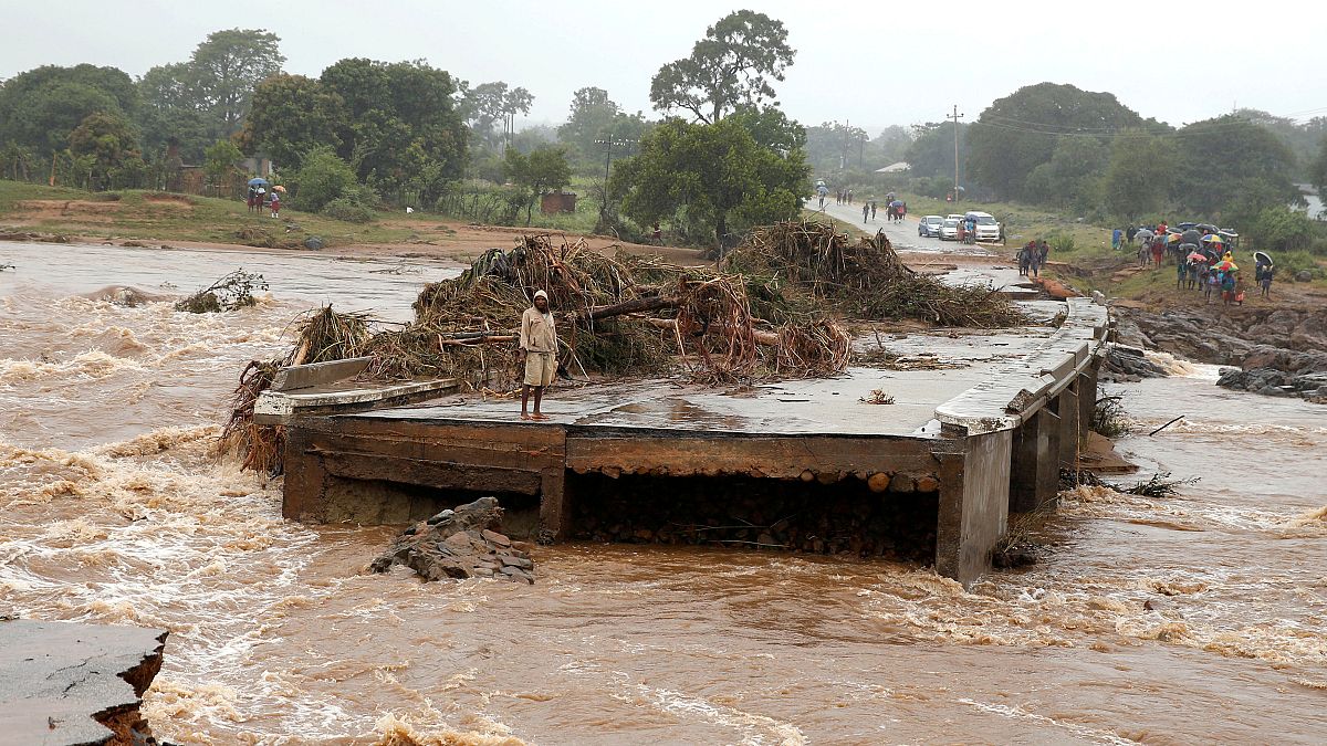 A man looks at a washed away bridge along Umvumvu river in Chimanimani