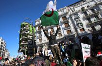 متظاهر يحمل العلم الوطني الجزائري في احتجاجات ضد الرئيس