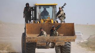 Fighters from SDF ride excavator in the village of Baghouz, Syria
