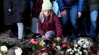 A girl lays flowers during a silent march in Utrecht to honour victim