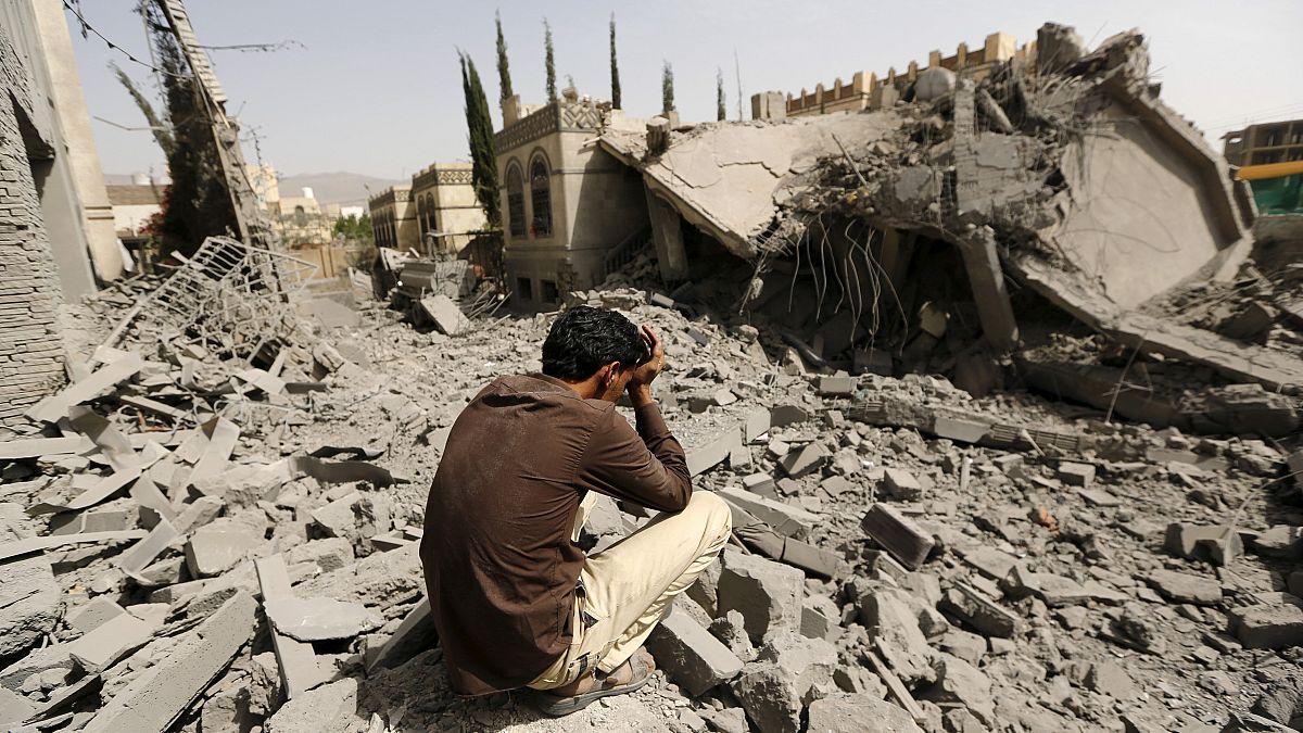 يمني يجلس على أنقاض منزل عسكري موال للحوثيين دمر إثر غارات جوية في صنعاء