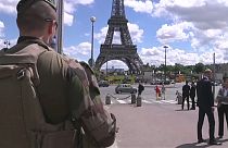 عسكري فرنسي يقف أمام برج إيفل وسط العاصمة باريس.