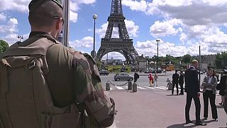عسكري فرنسي يقف أمام برج إيفل وسط العاصمة باريس.