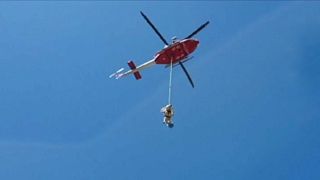 امدادگران ایتالیایی گاو اسیر شده میان صخره‌ها را با هلی‌کوپتر نجات دادند