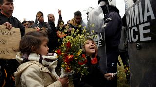 کودکان پناهجویان به پلیس ضدشورش گل هدیه می‌کنند- یونان- اردوگاه دیاواتا