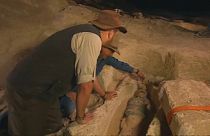 Archeologists observing mummy