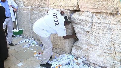 Clean out of written prayers from cracks of Jerusalem's Western Wall