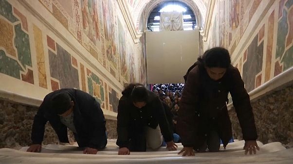 The faithful climb the Holy Stairs on their knees The faithful climb the Holy Stairs on their knees