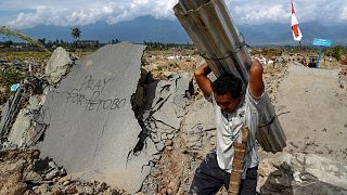 رجل إندونيسي يعمل بعد هزة أرضية ضربت البلاد منذ أيام