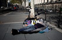 Paris'te bir evsiz metro havalandırmasının üzerinde uyuyor