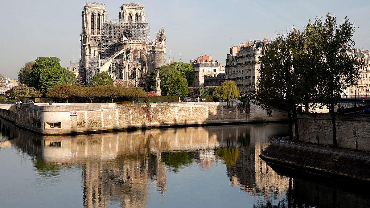 انعكاس صورة كاتدرائية نوتردام على مياه نهر السان في باريس بعد الحريق