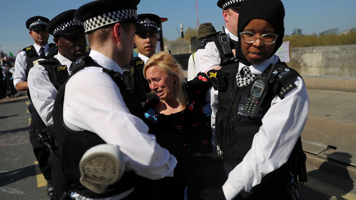 A climate change activist is detained during the London protest