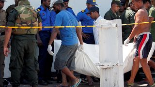 Men carry dead bodies towards ambulances in Colombo on April 21, 2019.