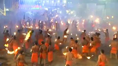 Hindu devotees throw flaming torches during Indian fire festival