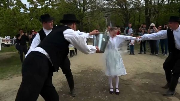 A young woman has a bucket of water chucked over her A young woman has a bucket of water chucked over her
